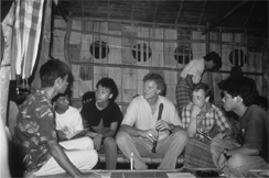 Lakey and another U.S. trainer in a guerrilla encampment in Burma in 1990, make music in a dorm with pro-democracy student soldiers who wanted to learn about nonviolent struggle.