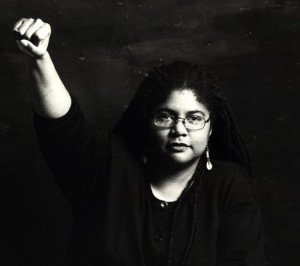 Black and white image of Linda Marie Thurston, with her right fist raised in the air. 