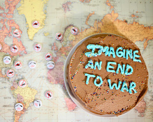 Chocolate cake with the words "Imagine and End to War" piped in blue frosting.