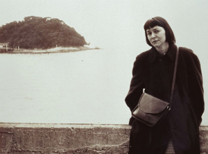 Barbara Deming standing in front of a body of water