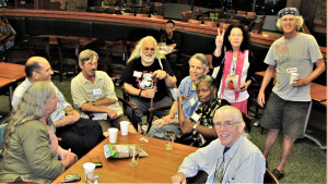 Bob Meola is seated with a group of comrades at WRL's 90th Anniversary Conference