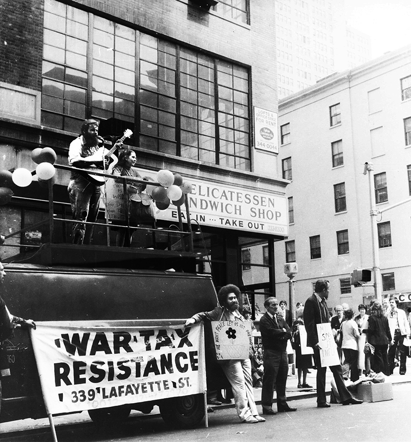 Charlie King singing atop a sound truck opposite the Manhattan IRS on Tax Day demonstration in 1975. Photo by Karl Bissinger